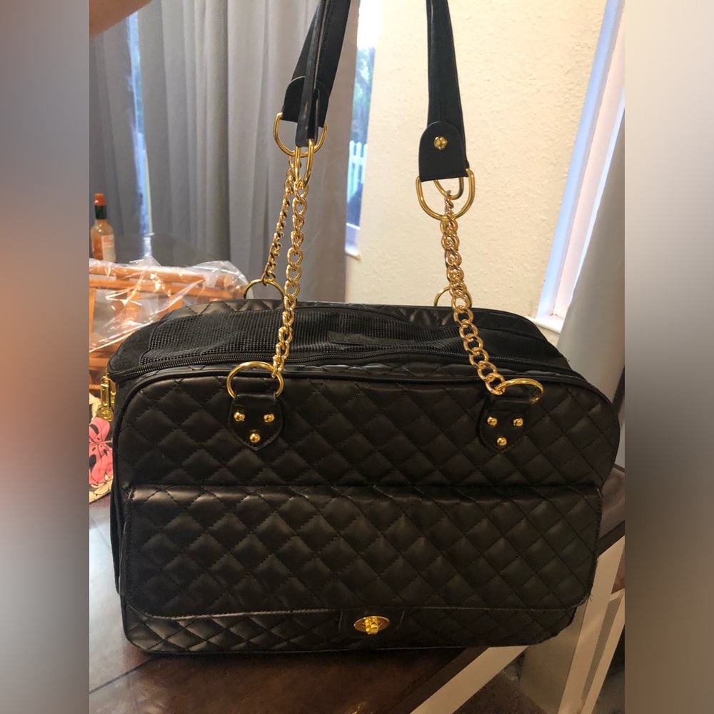 black quilted pet carrier tote with gold chain handles.